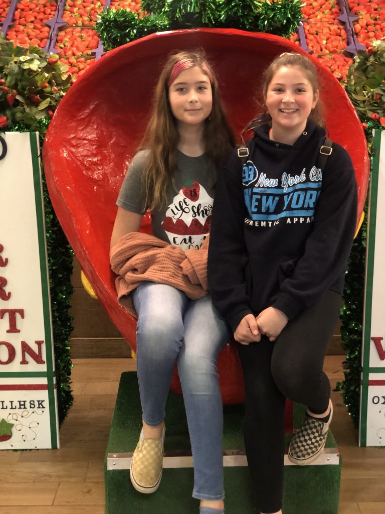 two girls sitting on the strawberry throne at Strawberry Festival