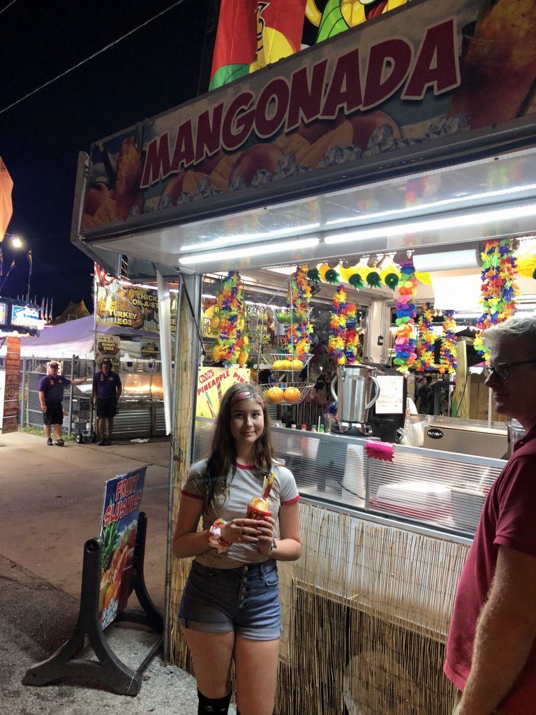 girl holding a slushie mangonada at the Florida Strawberry Festival.