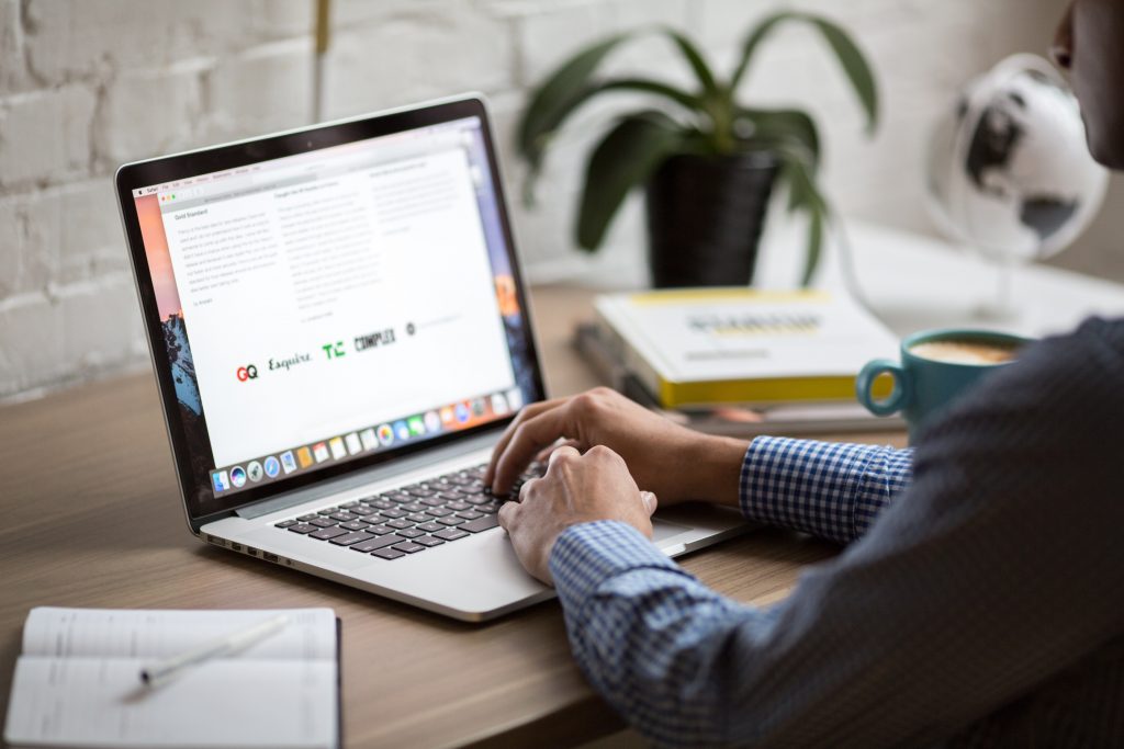 hands on a laptop on desk